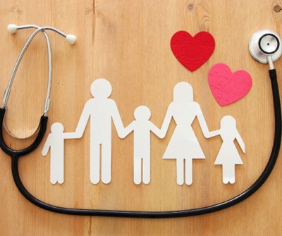 Stethoscope resting beside paper family cutouts and red hearts