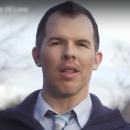 Smiling man in a sweater and tie reviewing life insurance options